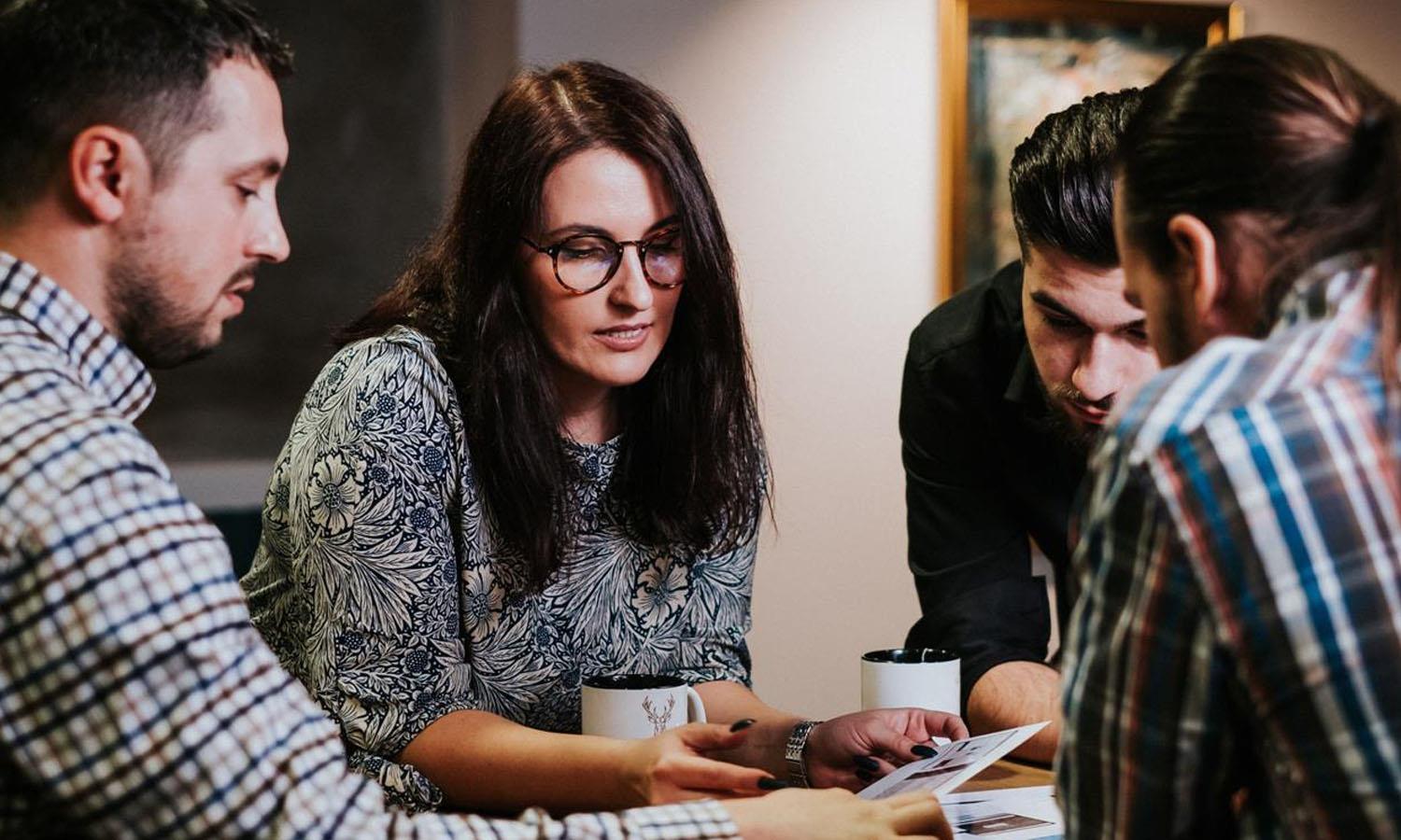 Four people at a table talking