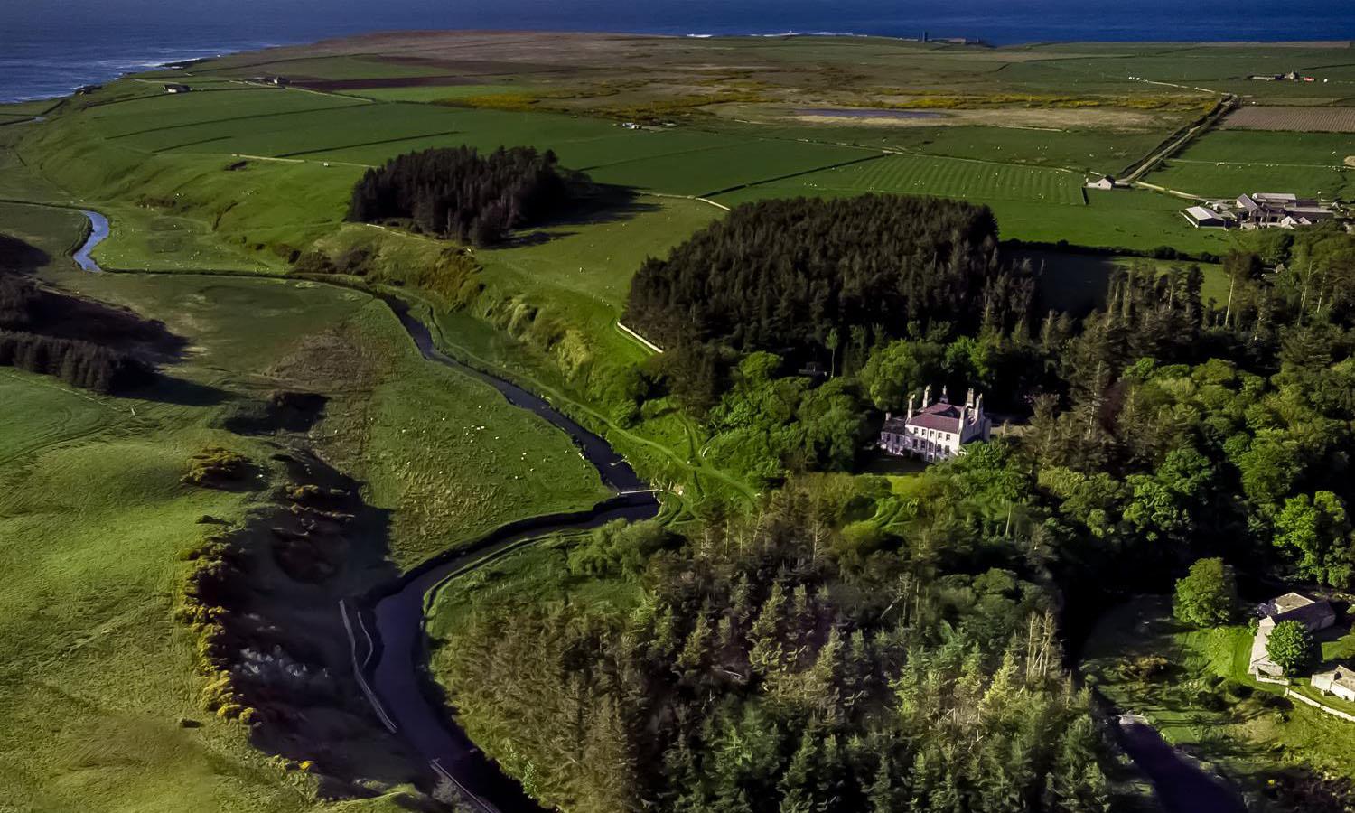 aerial shot of Forss House Hotel and surrounding countryside and sea