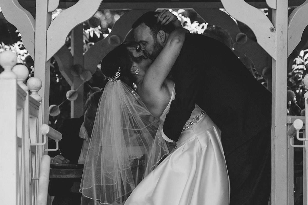 Black and white photo of Bride and groom kissing