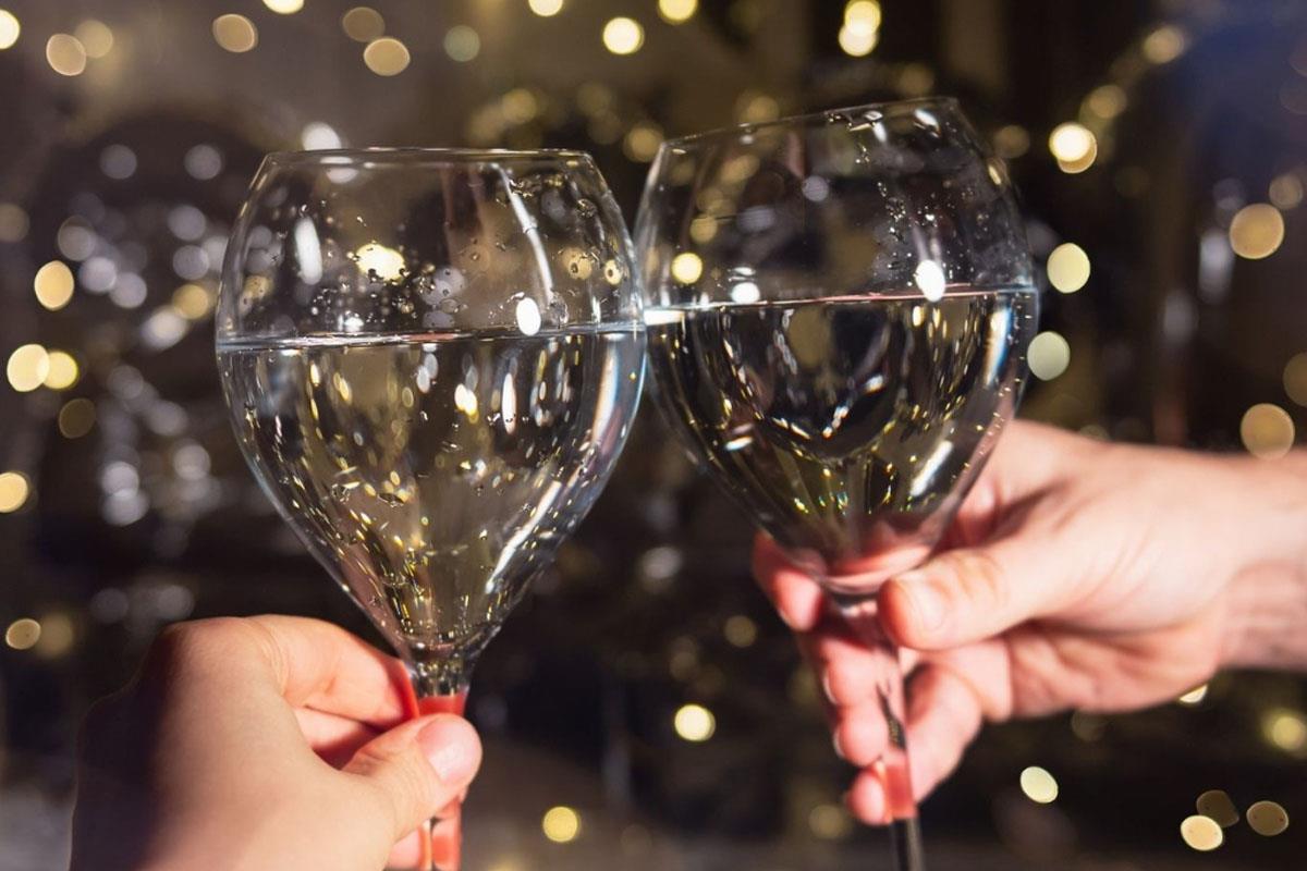 Champagne glass held in front of festive lights